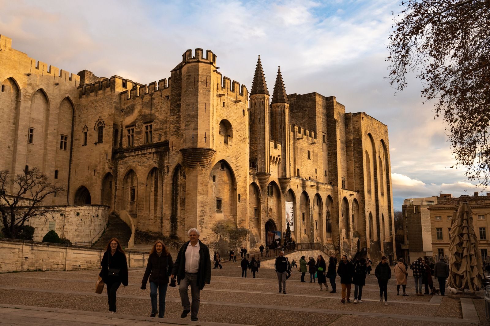 Photo by Bingqian Li Stunning view of the historic Palais des Papes with visitors in Avignon, France.