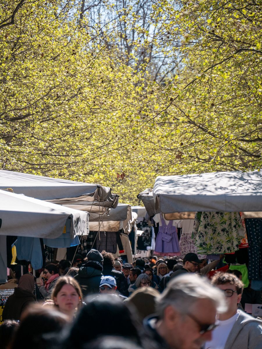 Marché provençal du samedi matin à uzès Un marché en plein air animé où les gens font leurs achats parmi les étals, à l'ombre des arbres verdoyants du printemps.